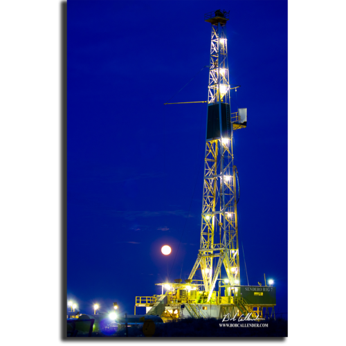 The moon behind a Sendero Rig and navy blue sky. Sendero Moon by Bob Callender