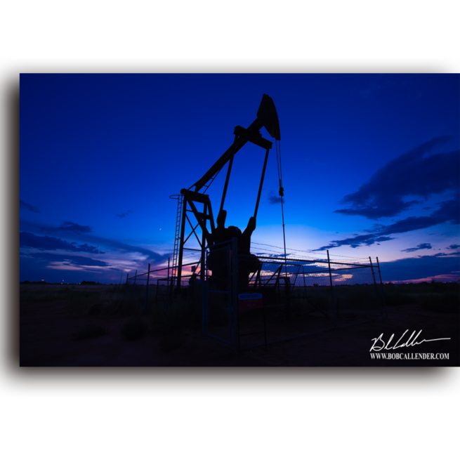 a Silhouetted pump jack with a blue Horizon by Bob Callender